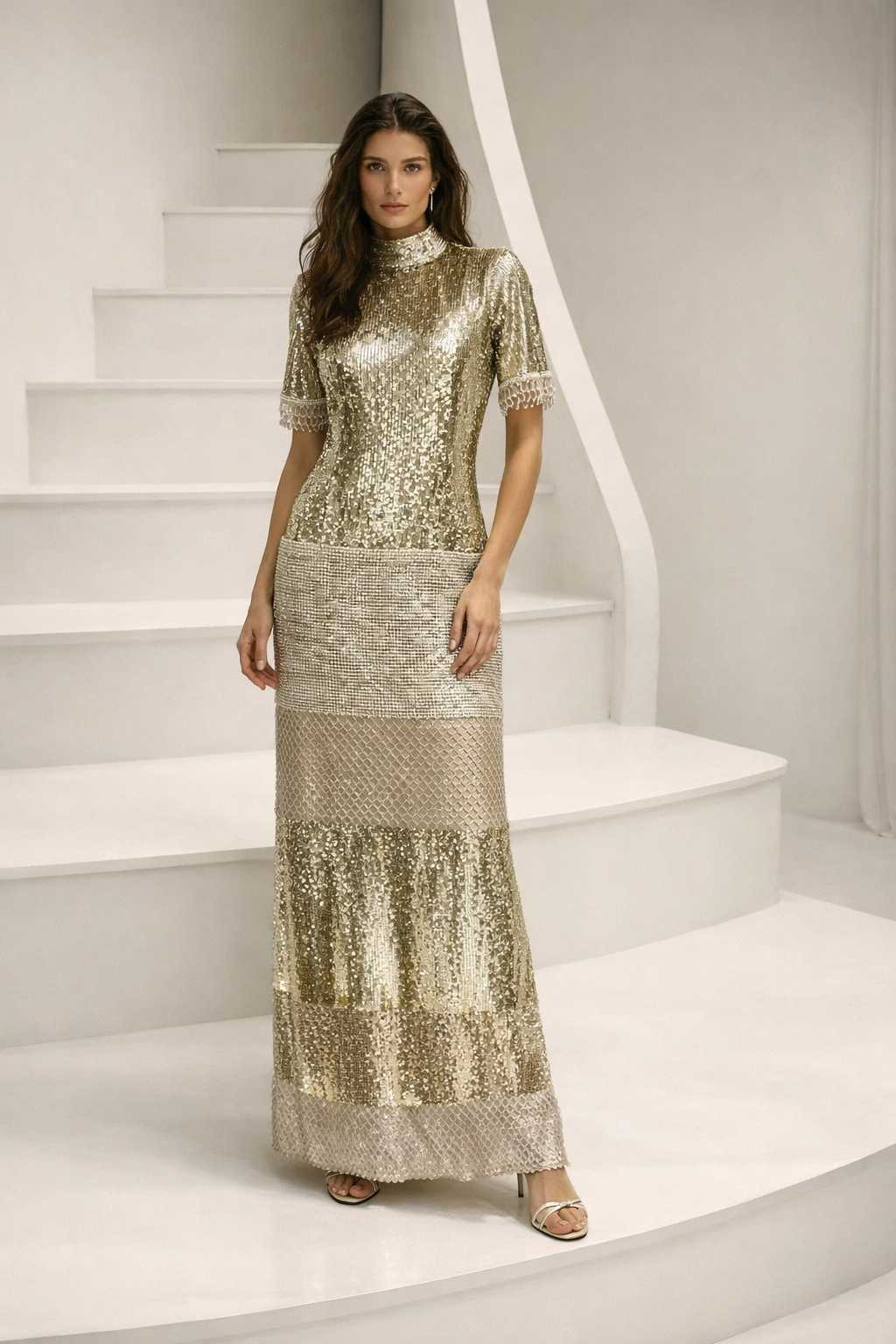 Woman in a sparkling gold dress standing on a staircase